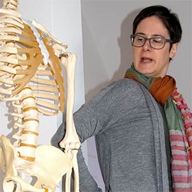 Vortragende Andrea Henschel demonstriert anatomische Grundlagen an einem Skelettmodell