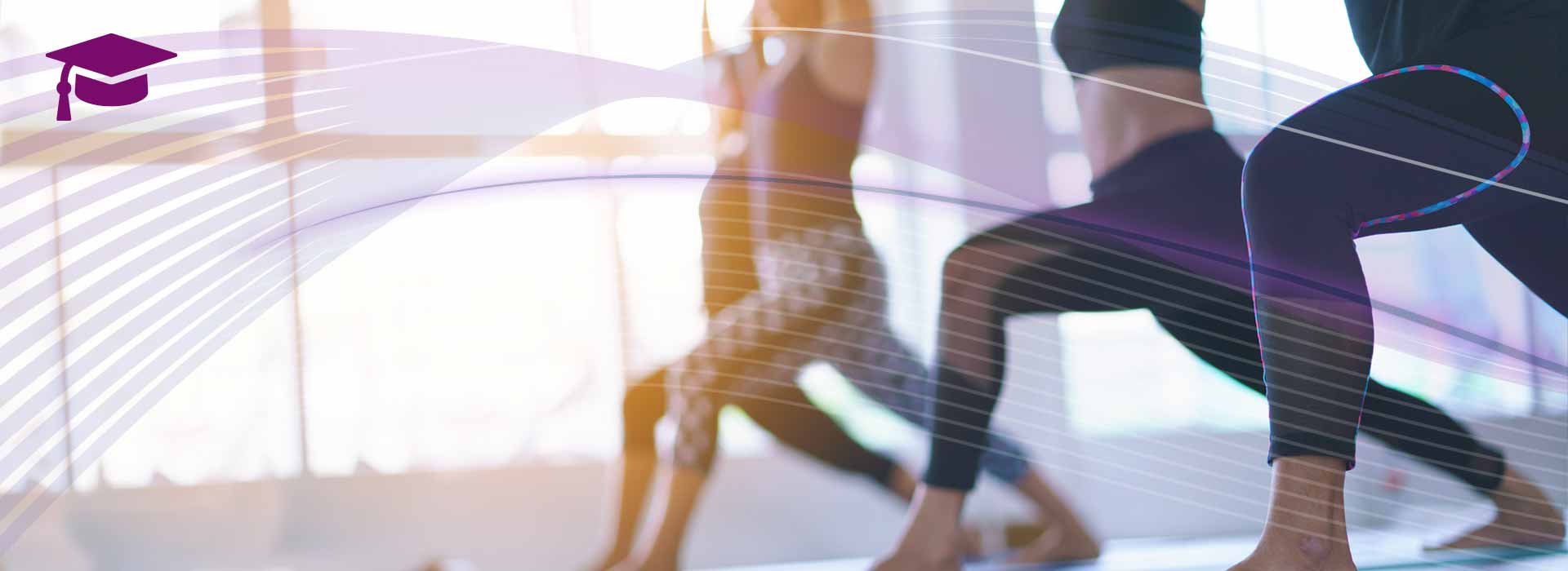 Eine Gruppe von Yogalehrenden trainieren in Sportdress mit Ausfallschritt und erhobenen Armen in einem großen Fitnesssaal, im Hintergrund eine lichtdurchflutete helle Fensterwand