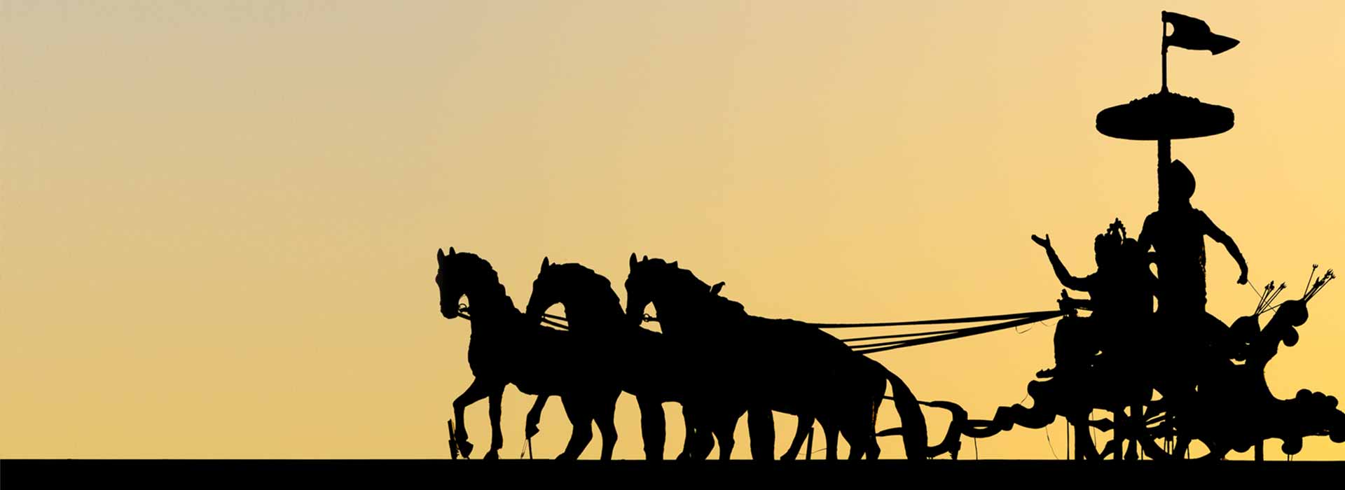 Abbild einer Plastik eines vierspännigen einachsigen indischen Streitwagens mit Wagenlenker und aufrecht stehender Gottheit Mahabharata mit überdimensionalem zeremoniellem Sonnenschirm als schwarze Silhouette vor rotgelbem wolkenlosen Abendhimmel