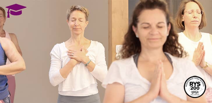 Teilnehmerinnen einer Yogalehrerausbildung von Yogaplus Studio Mainz bei einer meditativen Achtsamkeitsübung mit geschlossenen Augen und gefalteten Händen im Ausbildungsraum.