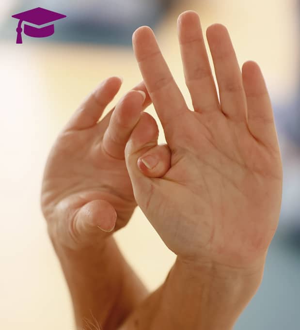 Mehrere Personen liegen auf Yogamatten in Rückenlage mit ausgestreckten Beinen, während Yoga-Lehrerin Susanne Weisheit einer Teilnehmerin achtsam assistiert.