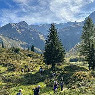 Teilnehmer:innen des Yogaplusretreats während einer Wanderung auf dem Naturschauweg in Sportgastein erleben die grüne Hochalpenlandschaft und das atemberaubende Bergpanorama mit Blick auf das Hohentauern-Massiv. (Foto: © Yogaplus/Susanne Weisheit)