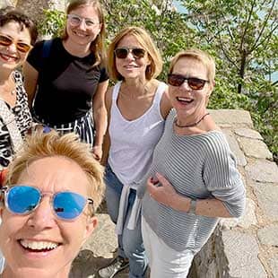 Selfie der Retreat-Leiterin Susanne Weisheit mit blau verspiegelter Sonnenbrille und 4 Retreat-Teilnehmerinnen vor einer Brüstungsmauer während einer Tour zur Festungsruine in Nafplio (Foto: © Yogaplus/Susanne Weisheit)